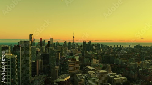 Stunning panoramic drone view in yellow green tones of modern downtown skyscrapers and Lake Ontario in evening Toronto, Ontario, Canada.