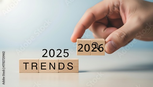 Hand changing wooden blocks from 2025 to 2026, symbolizing future trends and upcoming changes in the new year