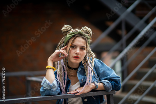 Woman with Dreadlocks in Denim Resting on Railing