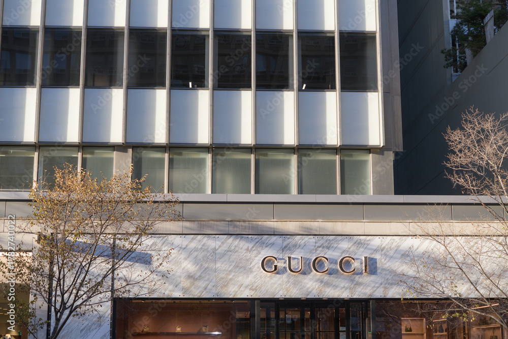 Obraz premium wide view of building and sign outside Gucci, a boutique with luxury brand merchandise, located at 130 Bloor St W, Suite 102, Toronto