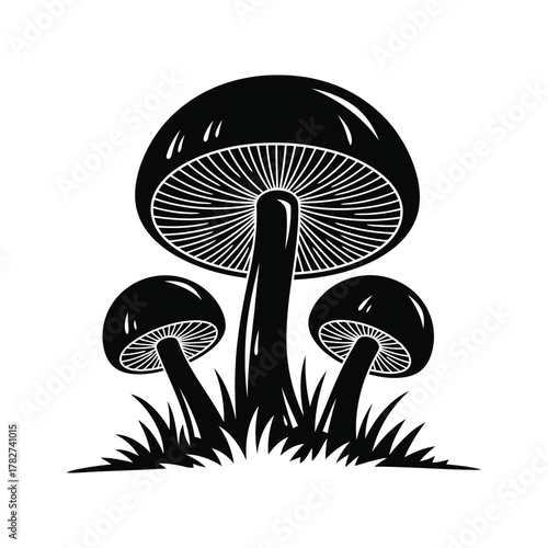 Black silhouette of three mushrooms growing in grass