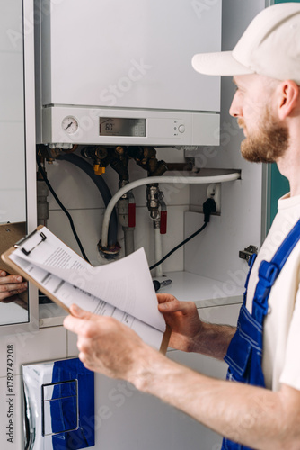 Photography Repairman performs maintenance on gas boiler in modern bathroom