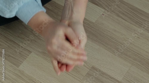 Woman in light blue shirt rattling mixed coins in cupped hand and pouring them into other palm.