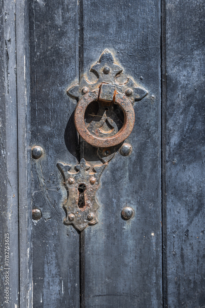 Fototapeta premium Rusted knocker on a black painted door.