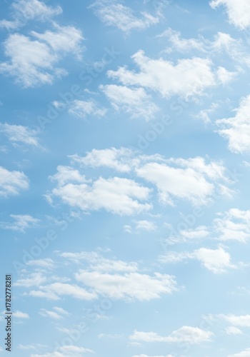 A peaceful, expansive light blue sky filled with scattered tiny white cumulus clouds on a bright sunny day, perfect for abstract backgrounds ,high ,soft ,texture