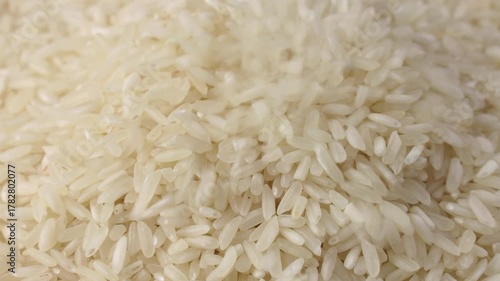 Uncooked white rice grains falling down close up