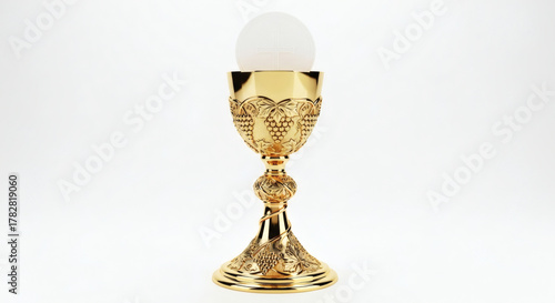 Golden chalice with grape design and white host on a white background
