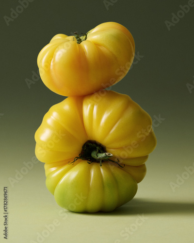 Yellow Heirloom Tomatoes Stacked Painterly Still Life on Green Seamless background. Film grain