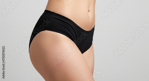 Close-up, textured studio shot of a woman's thigh and hip area, showcasing smooth, even skin texture, ideal for representing a successful cellulite smoothing or body contouring treatment.