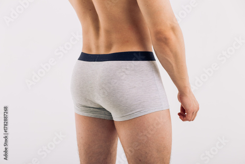 body parts: male ass in close-up in gray boxers on a white isolated background. male health: prevention of prostatitis and hemorrhoids