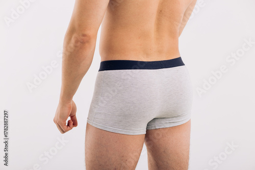 body parts: male ass in close-up in gray boxers on a white isolated background. male health: prevention of prostatitis and hemorrhoids
