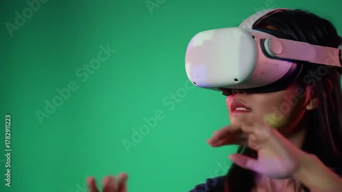 Young Woman Experiencing Immersive Virtual Reality with VR Headset Interacting with Digital World on Green Screen Background Future Technology and Metaverse Concept.