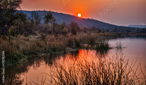 sunset over a body of water dam at Mokolodi Nature Reserve, located near Gaborone, Botswana