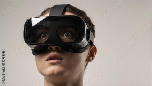 Young person wearing a virtual reality headset, looking amazed and excited.