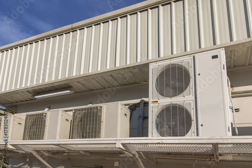 Air conditioner compressor installed in old building. Outdoor split wall type air conditioner compressor unit inverter installed on the outside of the building. Air conditioner compressor outdoor unit