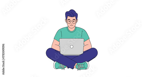 A cheerful young man with glasses sits comfortably cross-legged on the floor, working on his laptop with a focused and relaxed expression.