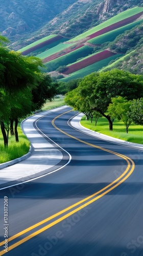 Scenic Winding Rural Road Through Lush Green Hillsides Under Bright Daytime Sunlight with Double Yellow Lines Guiding the Way Past Tall Trees and Cultivated Terraces