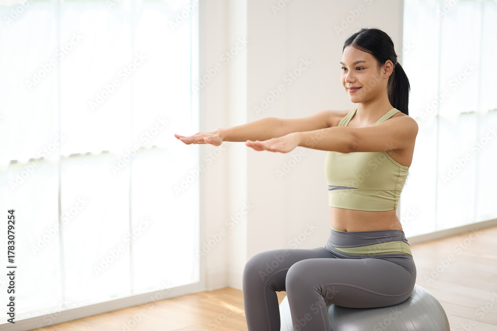 Fototapeta premium Woman sitting and doing fitness ball workout