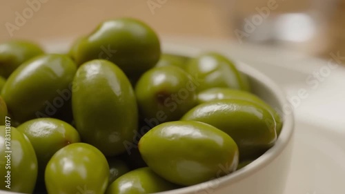 Close-up shot of a bowl of fresh, green olives, showcasing their vibrant color and texture Stock Video