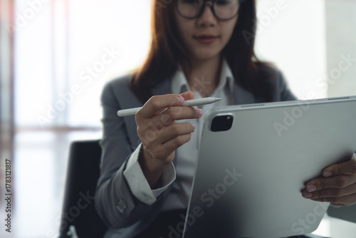 Photography Business woman using digital tablet, proofreading e-document, working at office