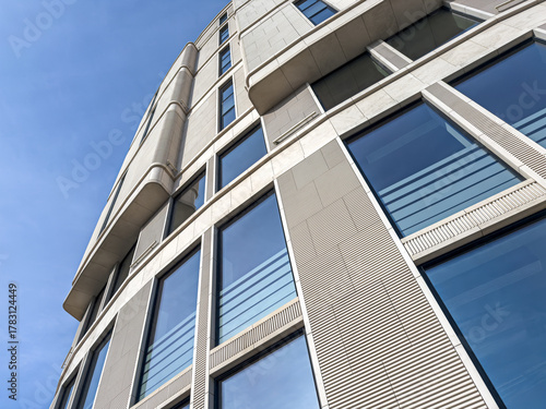 bottom view of modern business building against blue sky in downtown.
