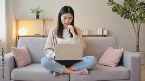 Serene Productivity: A person sits comfortably on the couch, laptop in lap, engaging in focused work at home environment. capturing the essence of modern lifestyle.