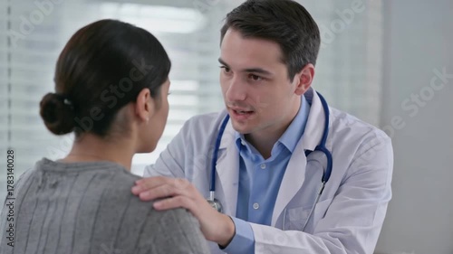 Empathetic Doctor's Consultation: A compassionate doctor, stethoscope draped, offers a comforting hand on the shoulder of a patient. In a modern medical setting, empathy and assurance are shared.