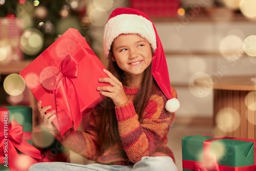 Little girl in Santa hat an...