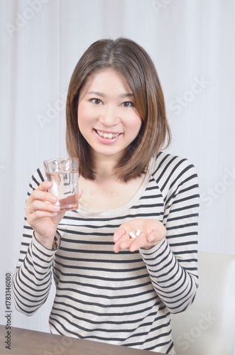 サプリメントを飲む若い日本人女性