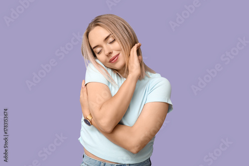 Young woman hugging herself...
