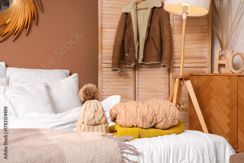Winter clothes on bed in co...