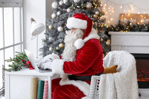 Santa Claus using laptop at...