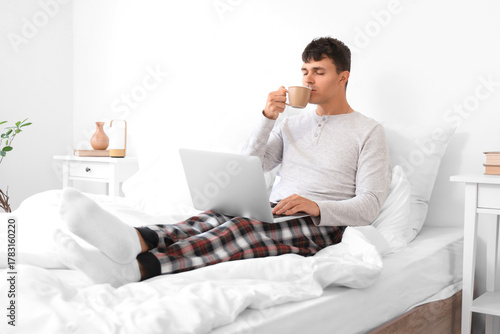 Young man with laptop drink...