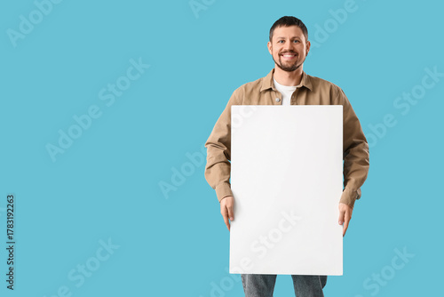 Young man with blank poster...