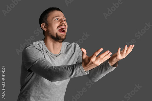 Screaming young man on dark...