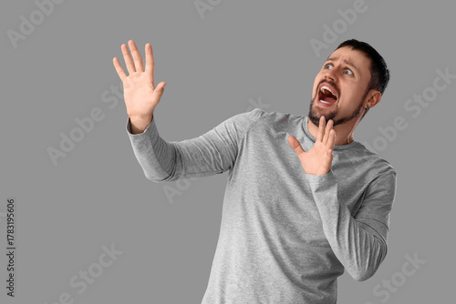 Scared young man screaming ...