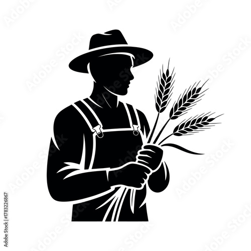 A farmer in overalls and a hat holds a stalk of wheat.