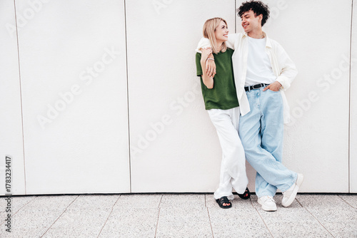Smiling beautiful woman and her handsome boyfriend. Couple in casual summer clothes. Happy cheerful family. Female and man having fun. They posing in the street in sunny day. Having tender moments