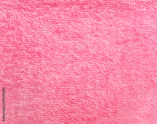Terry towel or carpet of pink color. Background with fluffy towel terry cloth. Natural cotton fabric texture. Long pile canvas. Close-up of soft cotton terry cloth. Material of domestic cotton rug