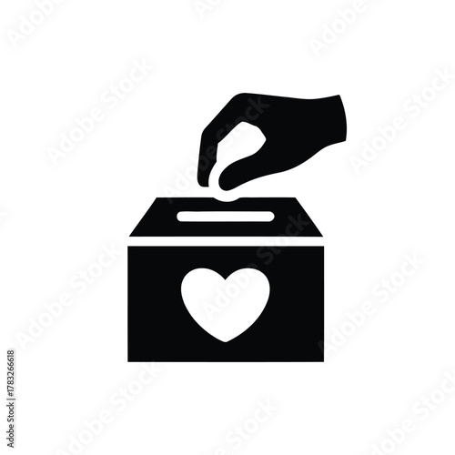 Hand putting coin in donation box with heart