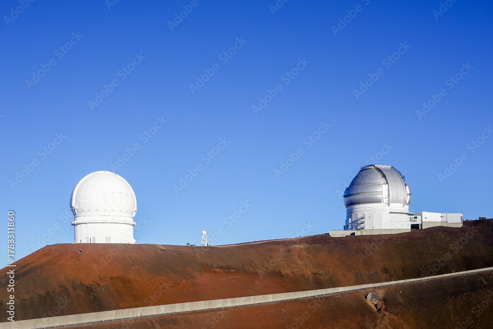 Fototapeta premium Twin white observatory domes on rust colored volcanic ridge
