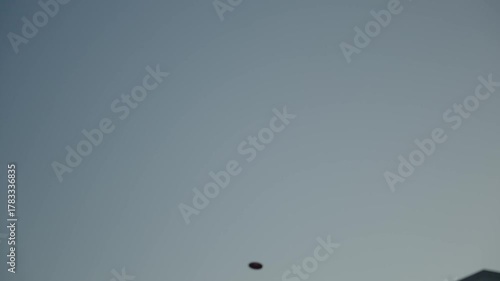 Flight of a throwing disc against the background of the sky. Shot in slow motion