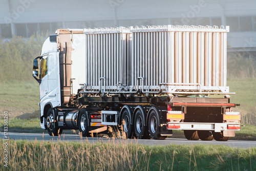 Obraz na plátně White truck hauling metal tube containers