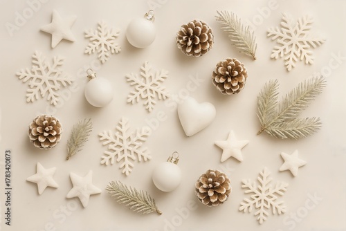 Soft and minimalist flat lay with white Christmas ornaments, pinecones and snowflakes on beige background, cozy winter aesthetic