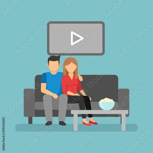 Couple sits on couch watching tv with popcorn on table.