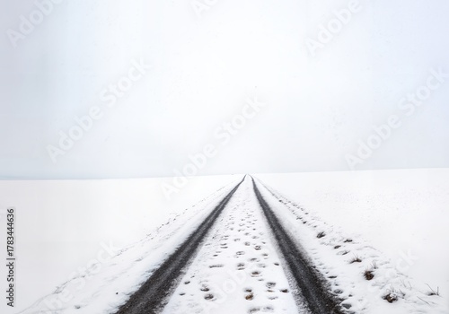 Minimalist Winter Landscape with Diagonal Path Through Snowy Field Leading to Atmospheric Horizon