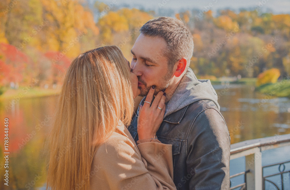 Fototapeta premium Elegant European couple walking together through picturesque city streets. Warm autumn light, gentle smiles, and cinematic vintage atmosphere