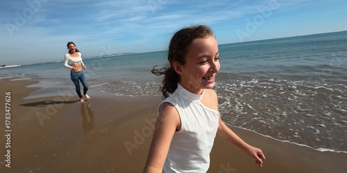 A mother and her daughter are running and enjoying on the beach