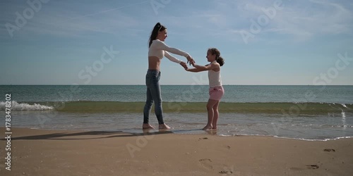 A mother and her daughter are running and enjoying on the beach