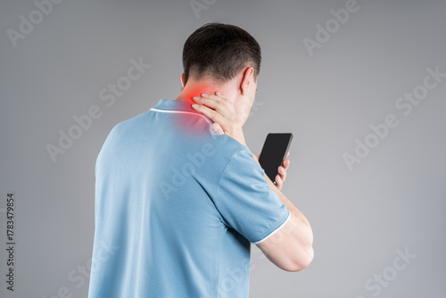 Man with neck pain from using smartphone, text neck and bad posture concept